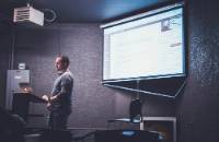 man standing in front of powerpoint presentation
